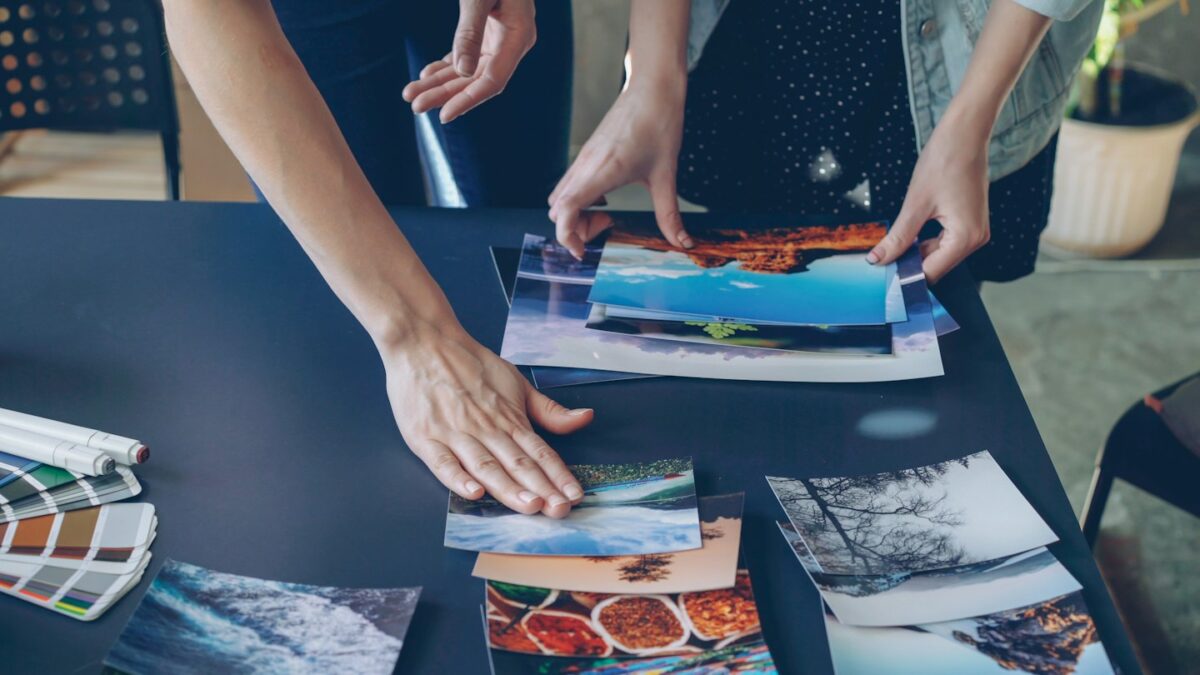 People are arranging photos on a table