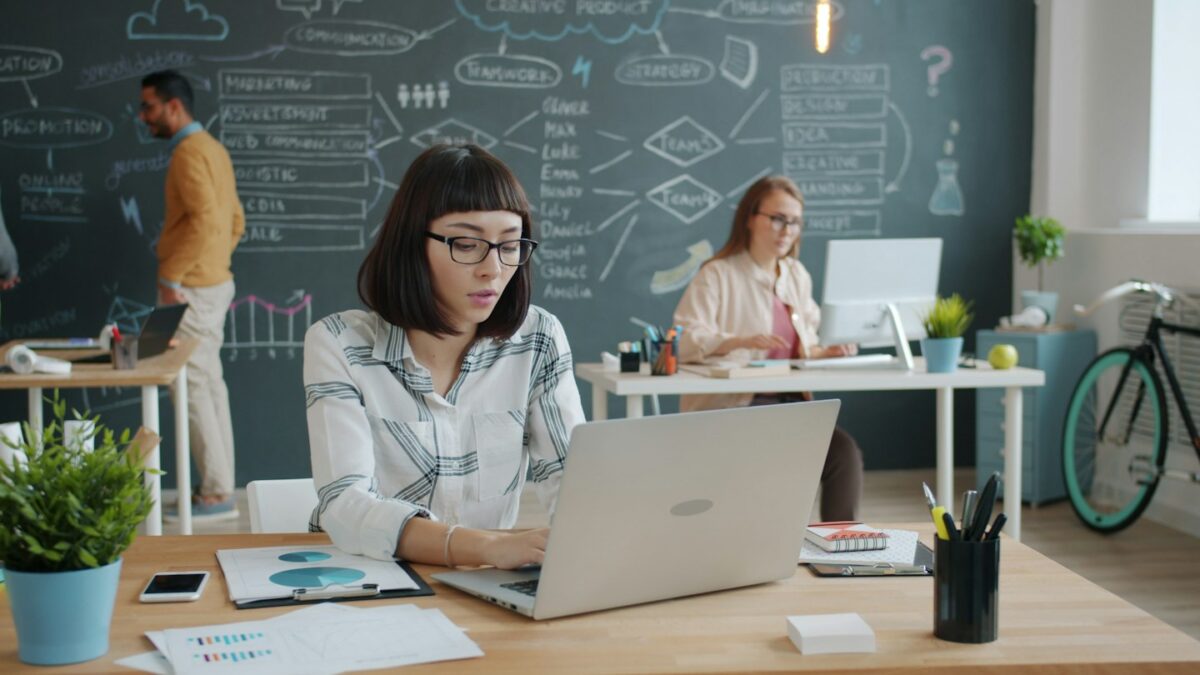 People working in a modern office with a chalkboard wall