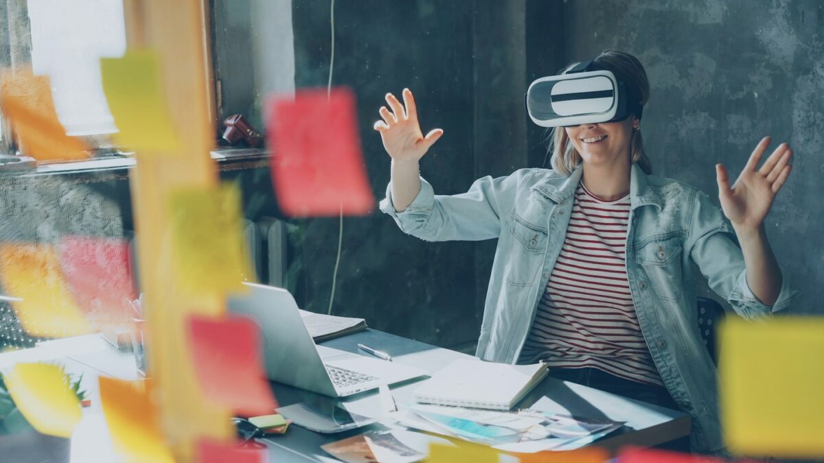 Woman happily experiencing virtual reality at her desk