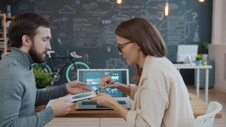 Two colleagues discussing a project at a desk
